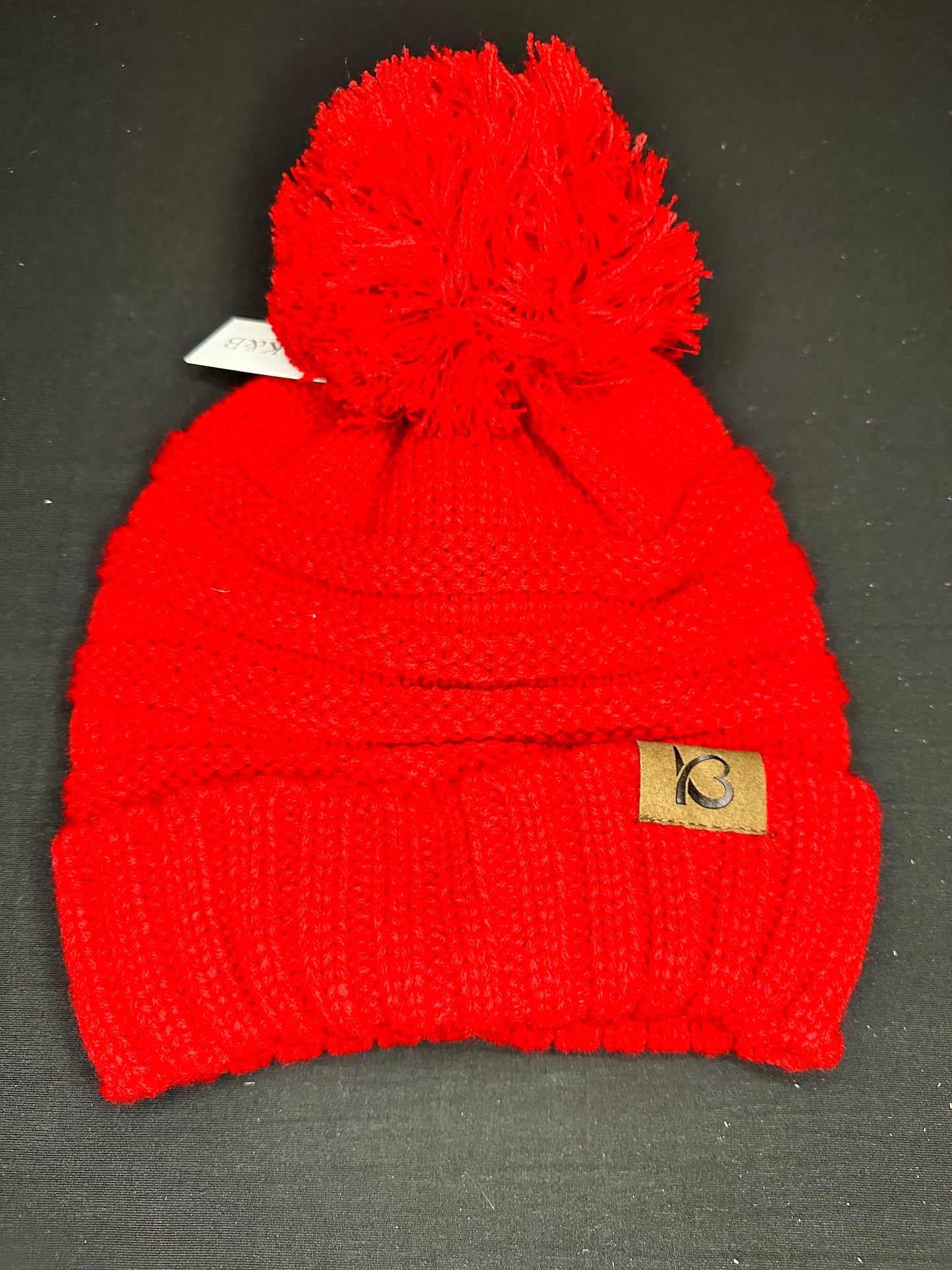 Red knit beanie with pom pom on top