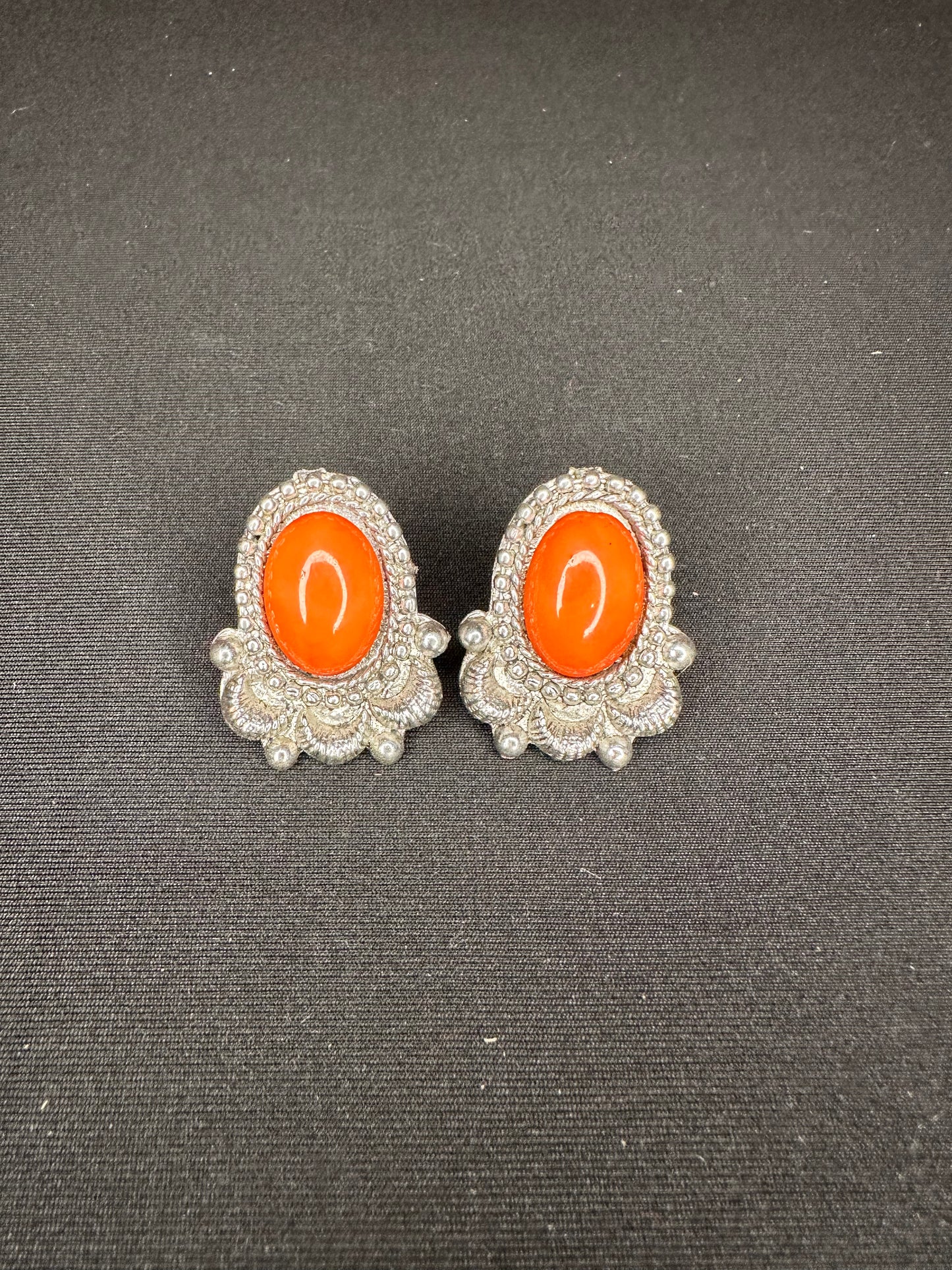 Orange stone surrounded by detailed silver stud earring