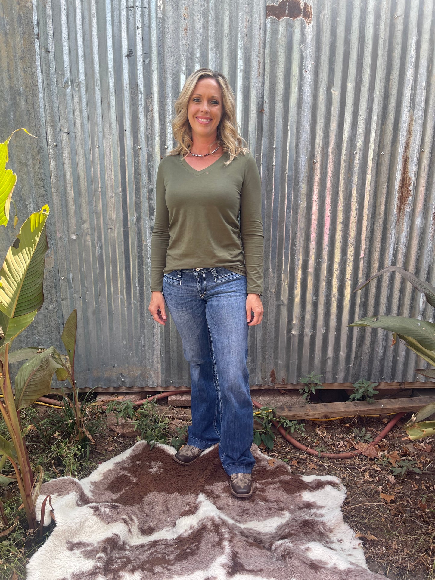 Woman wearing olive long sleeve v-neck in size medium
