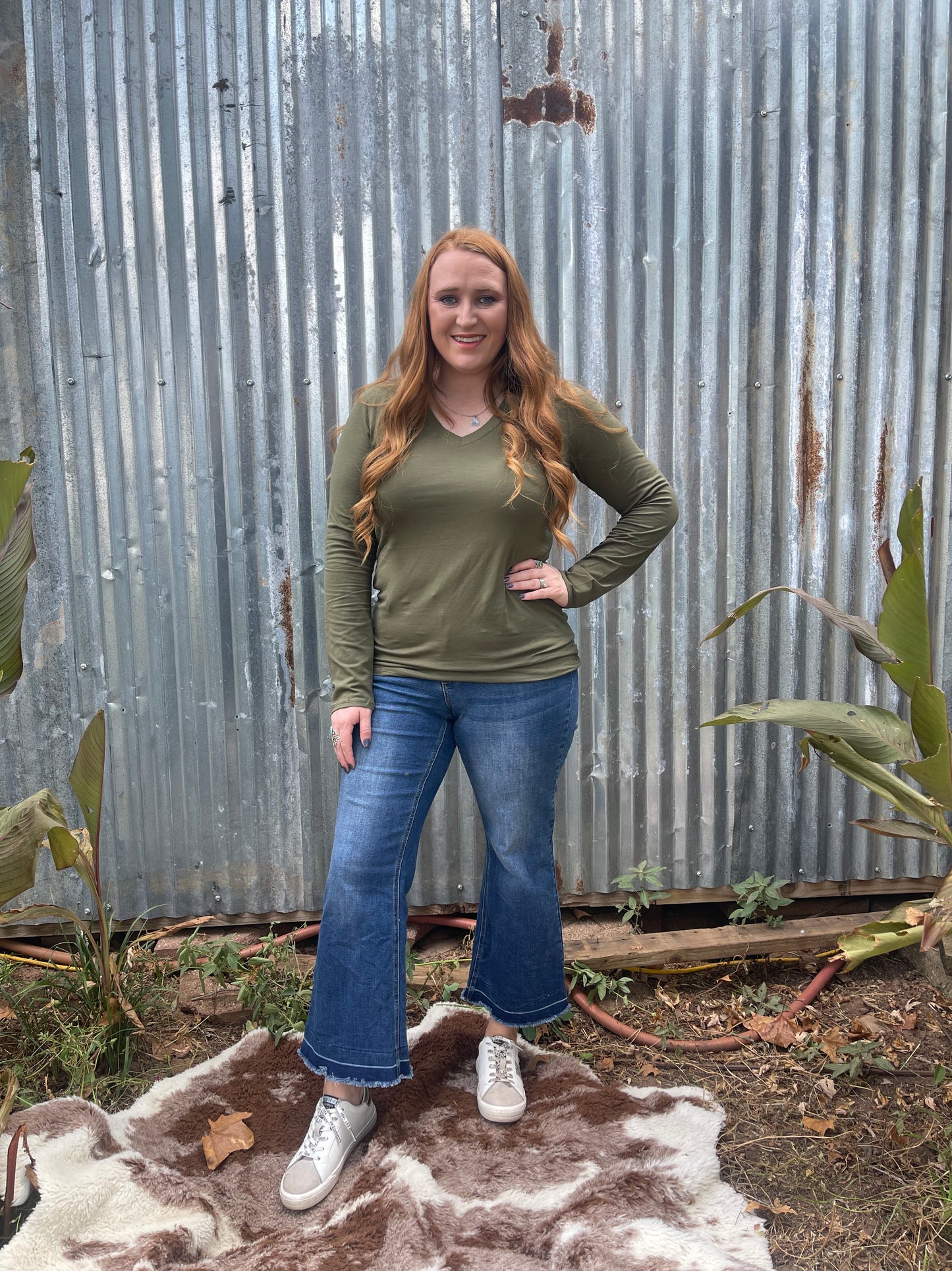 Woman wearing olive long sleeve v-neck in size x large