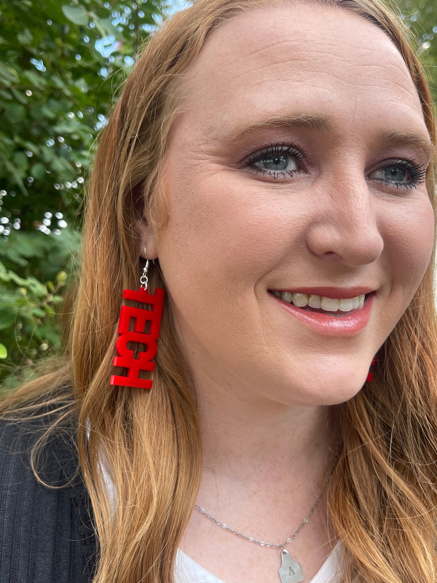 Woman wearing red TECH earrings