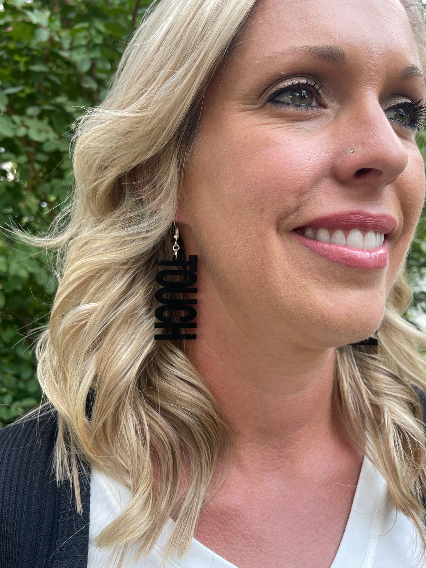 Woman wearing earring that says TOUCH