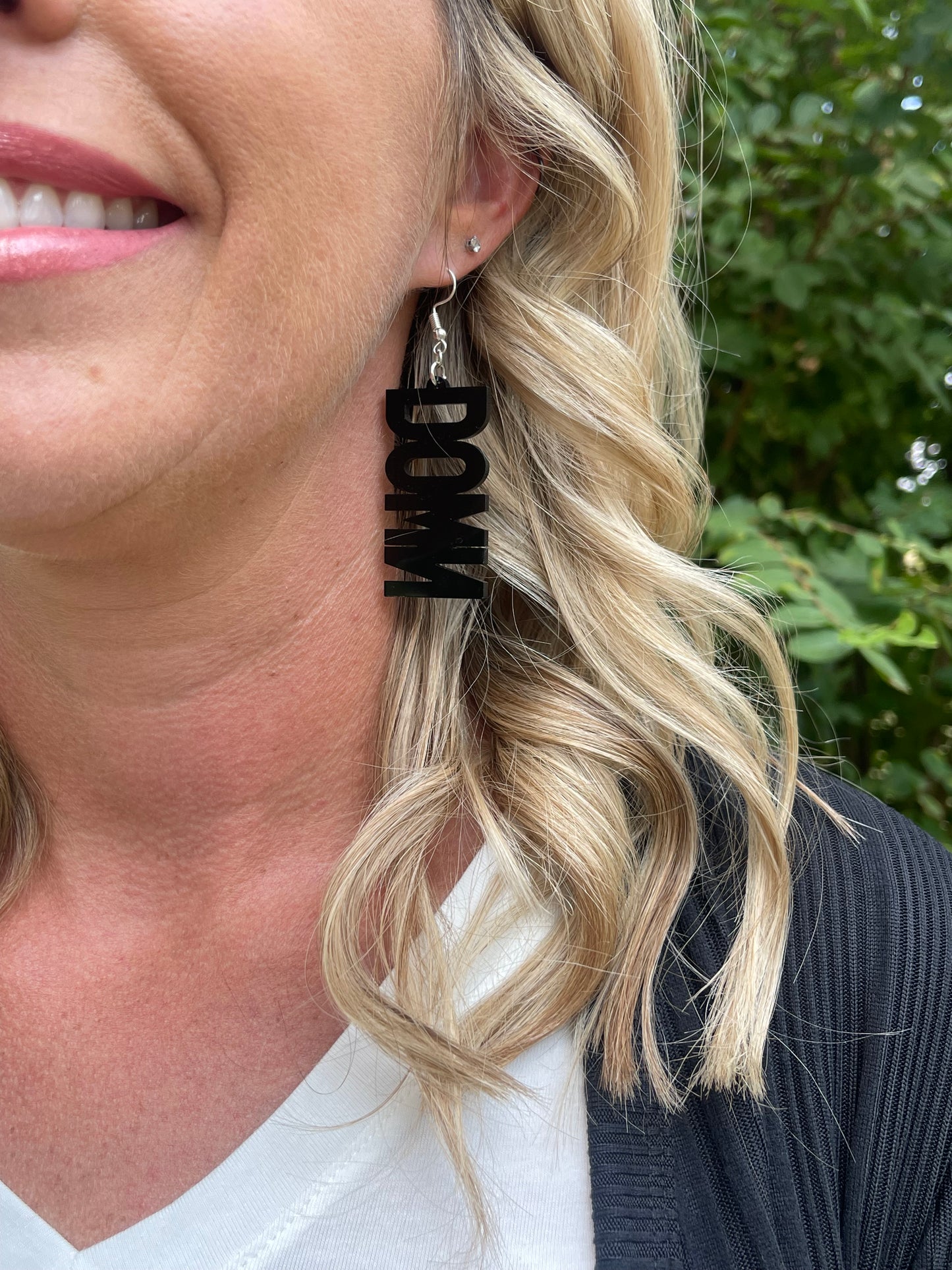 Woman wearing earring that says DOWN