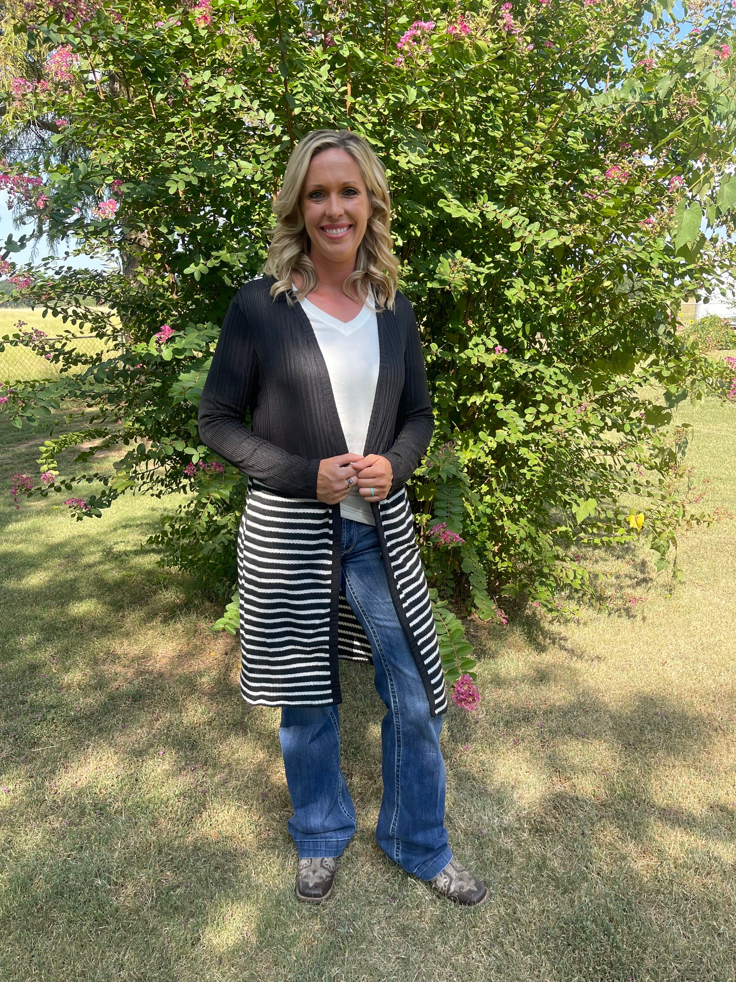 Woman wearing long, black and white striped duster with pockets in size small