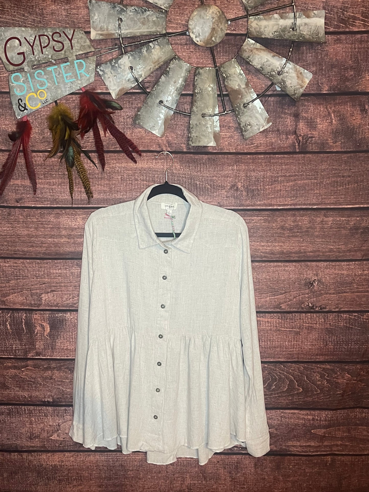Oatmeal colored babydoll button down top with ruffled high low hem
