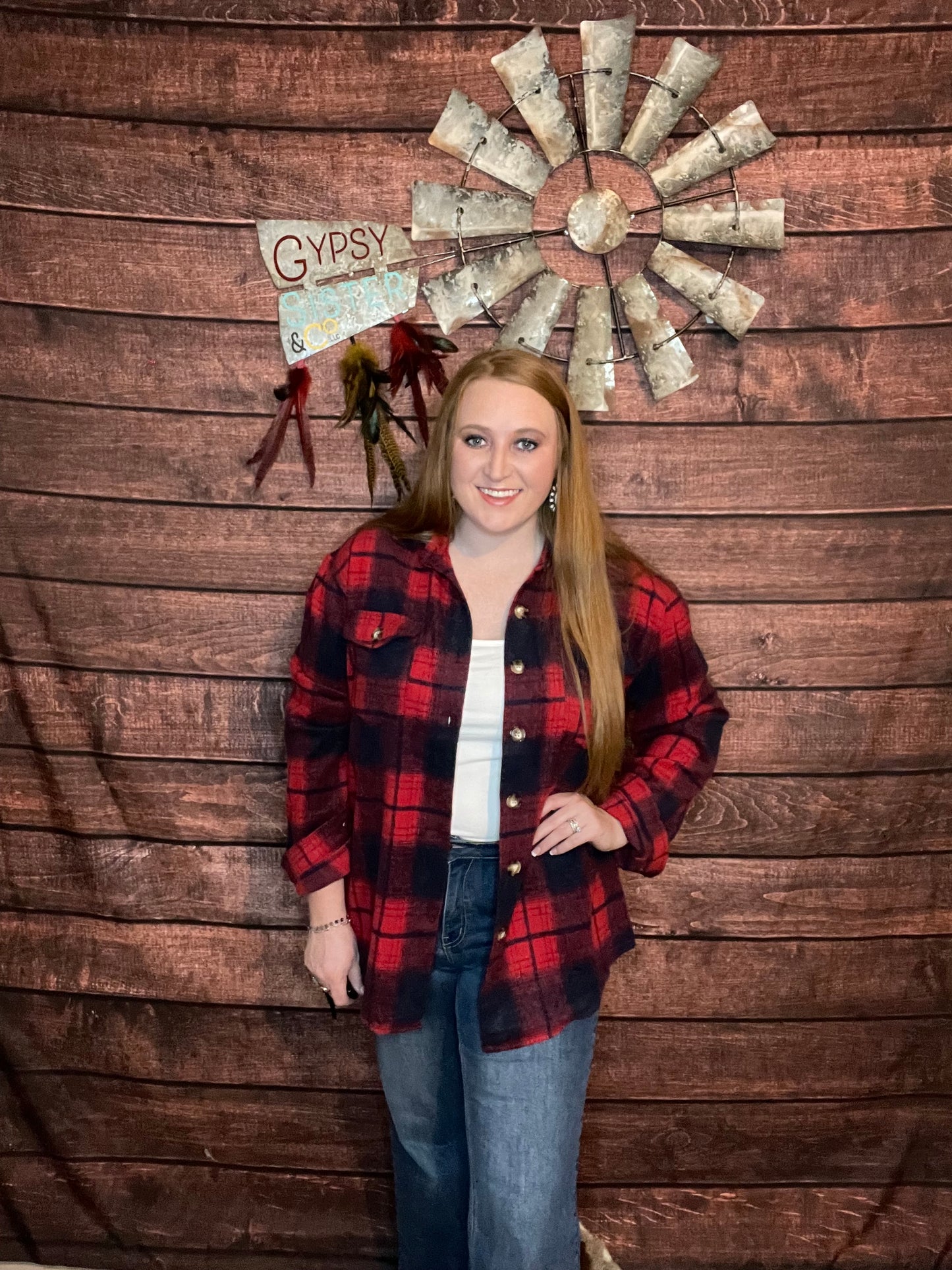 Model wearing red plaid shacket with jeans