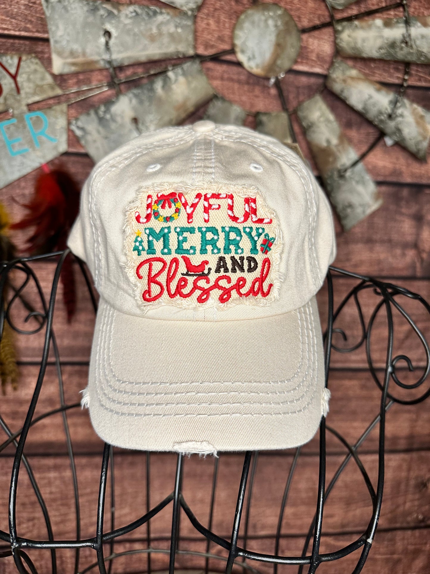 Cream colored distressed ball cap with distressed patch that says "Joyful Merry and Blessed"