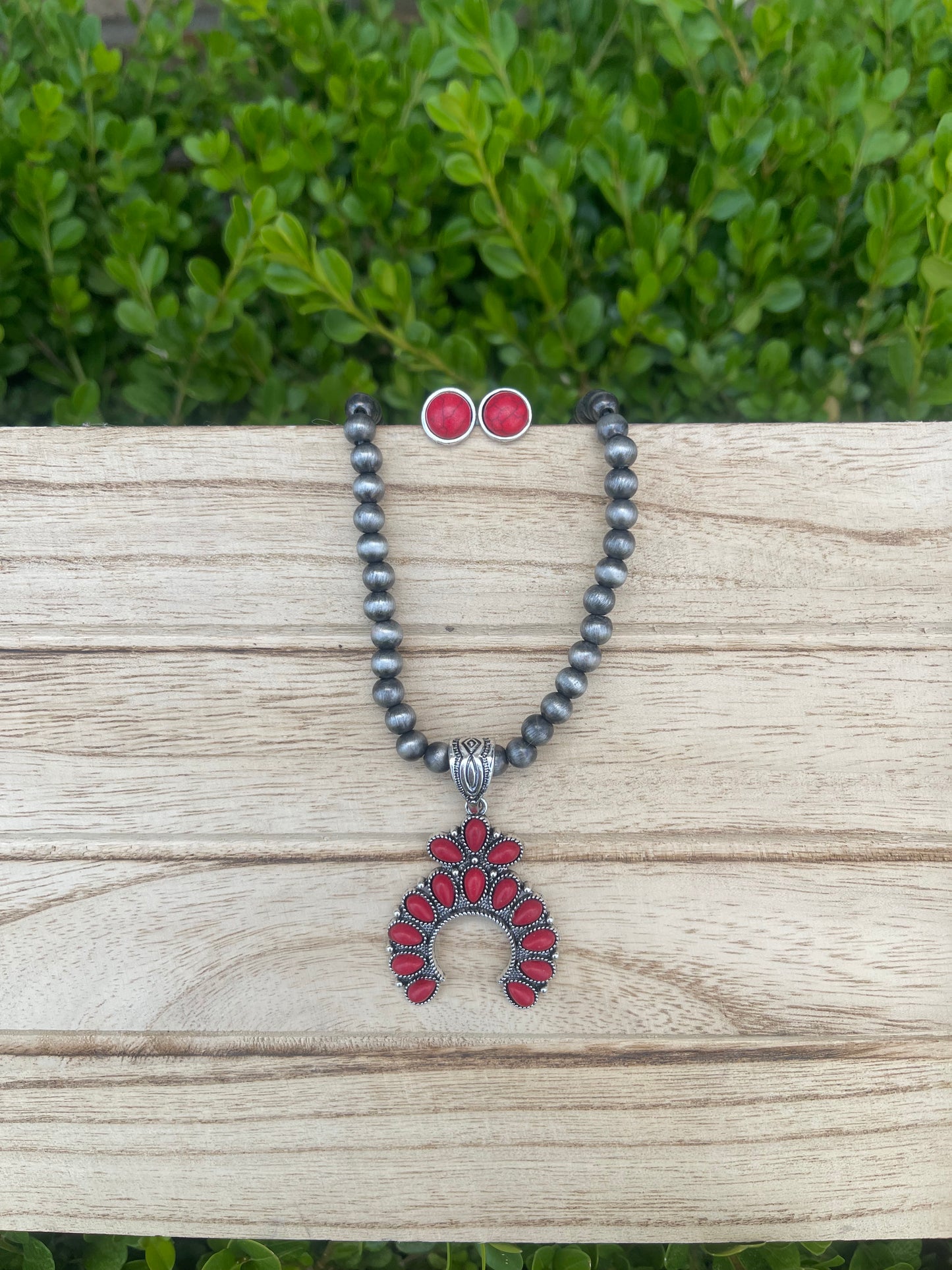 Small red squash blossom on a grey Navajo pearl chain with matching red stud earrings