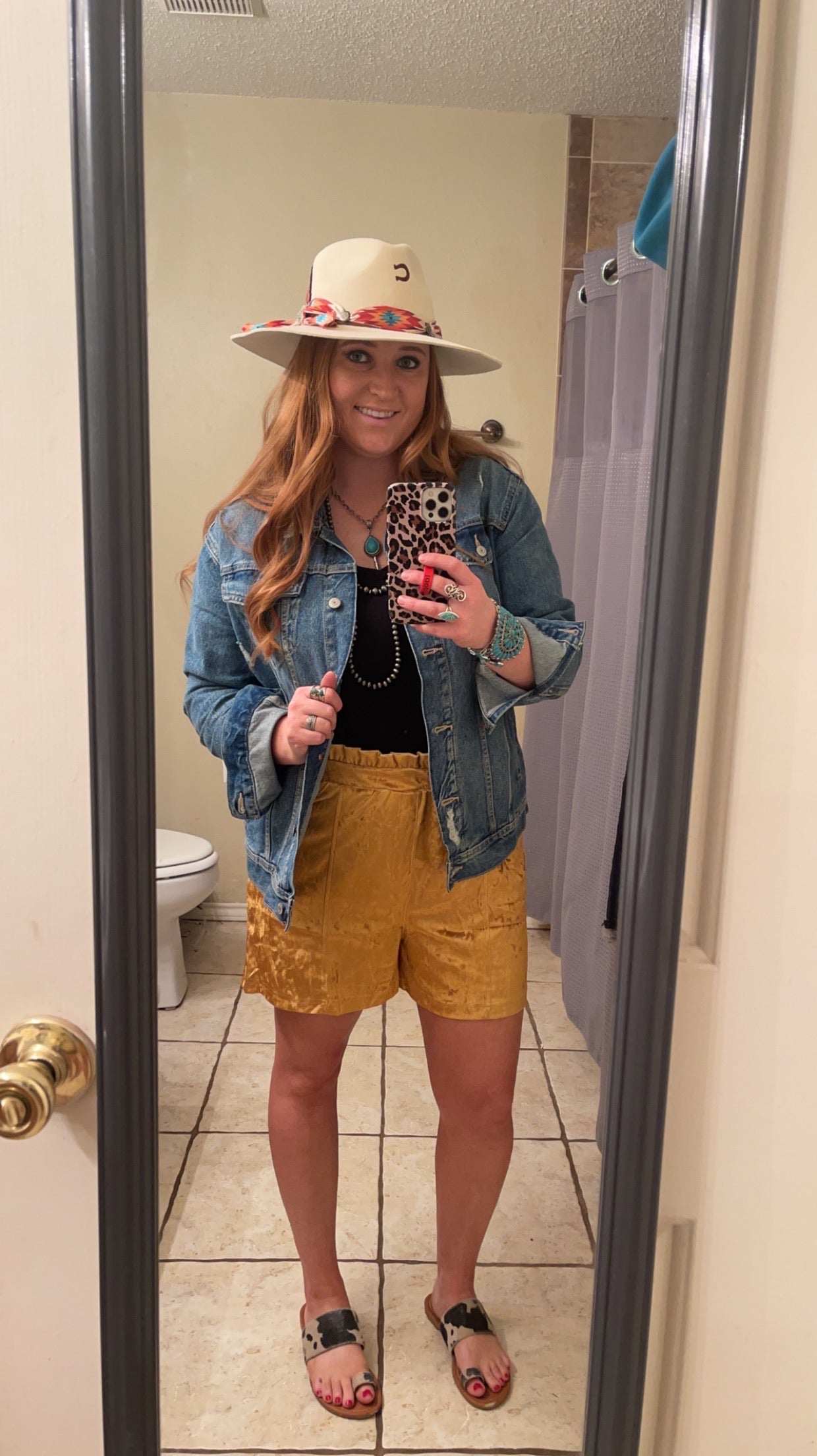 Model wearingVelvet Mustard yellow shorts with a black shirt and denim jacket.