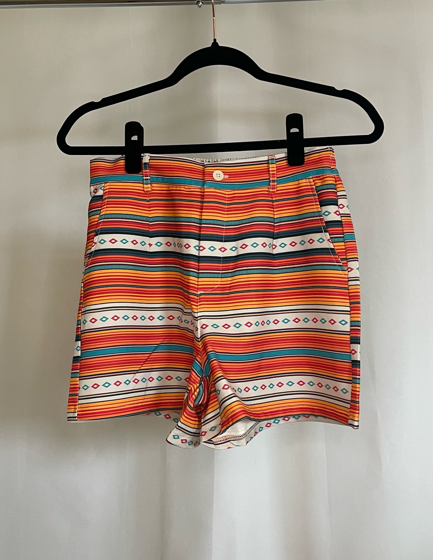 Front of orange, yellow, turquoise serape print shorts
