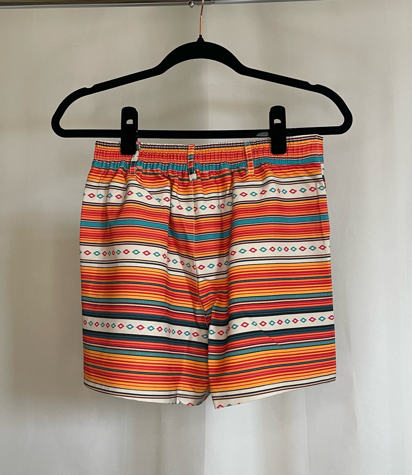 Back of orange, yellow, turquoise serape print shorts to show stretchy elastic band
