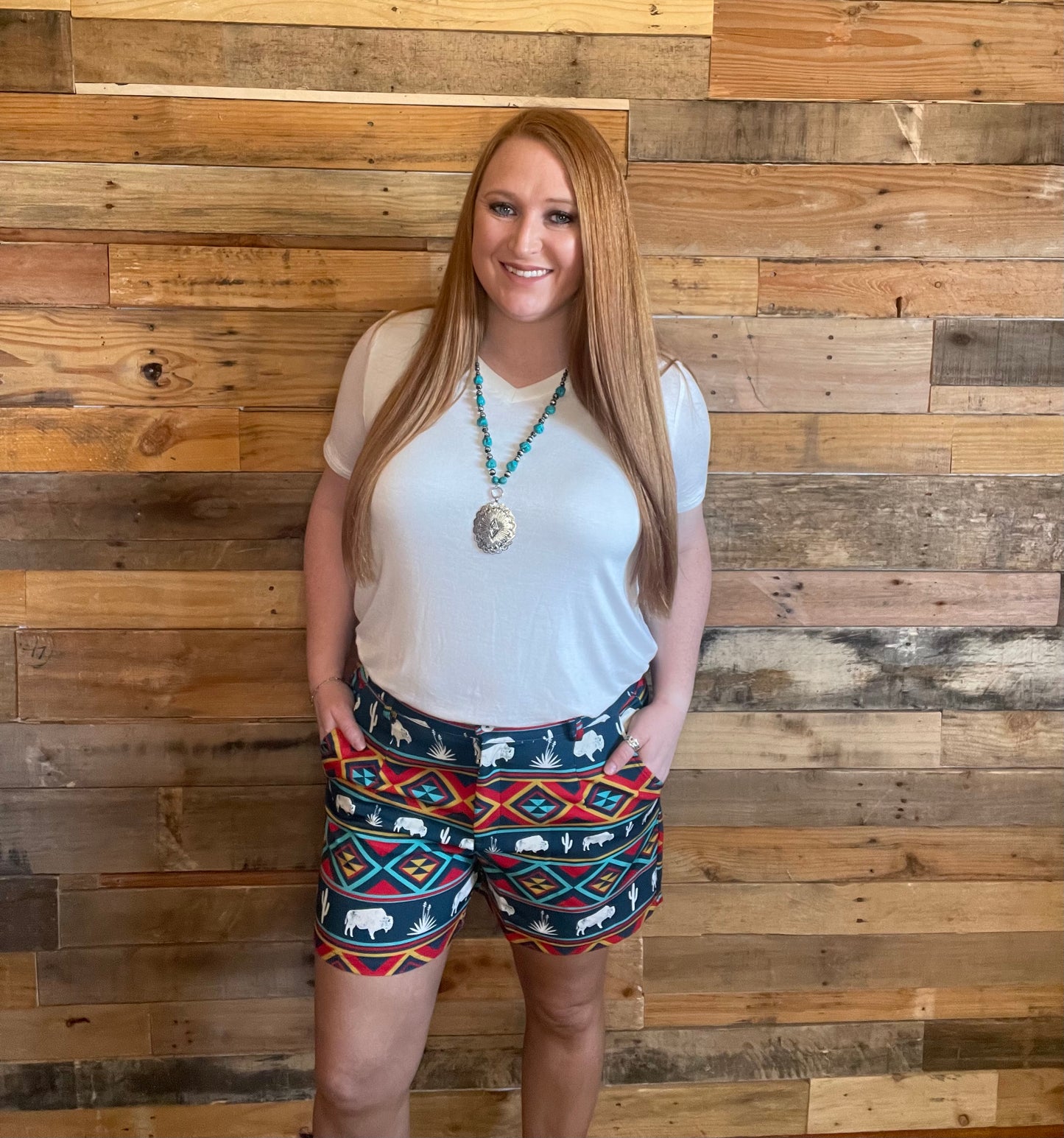Model wearing tribal and buffalo print shorts with a white shirt
