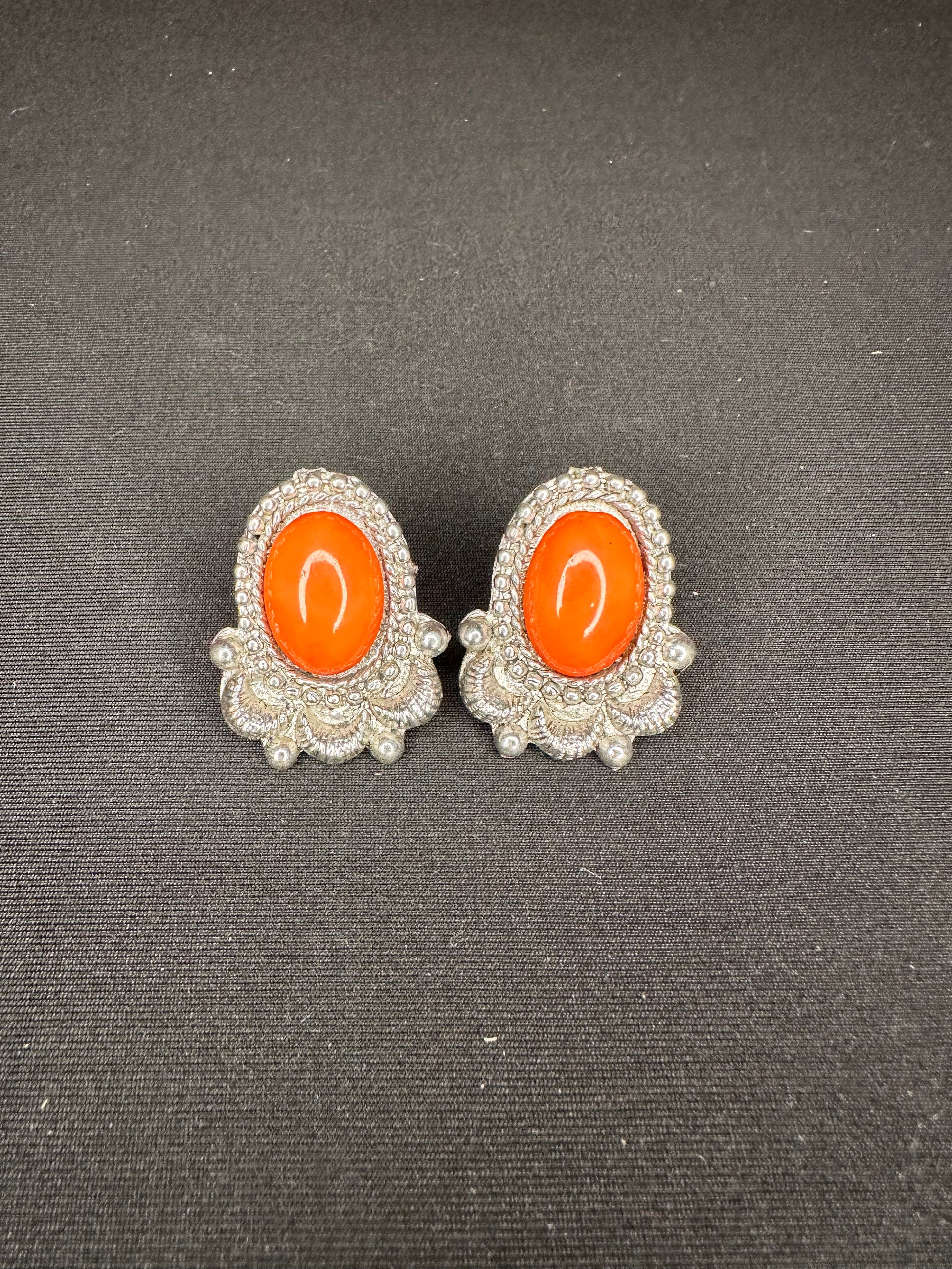 Orange stone surrounded by detailed silver stud earring 