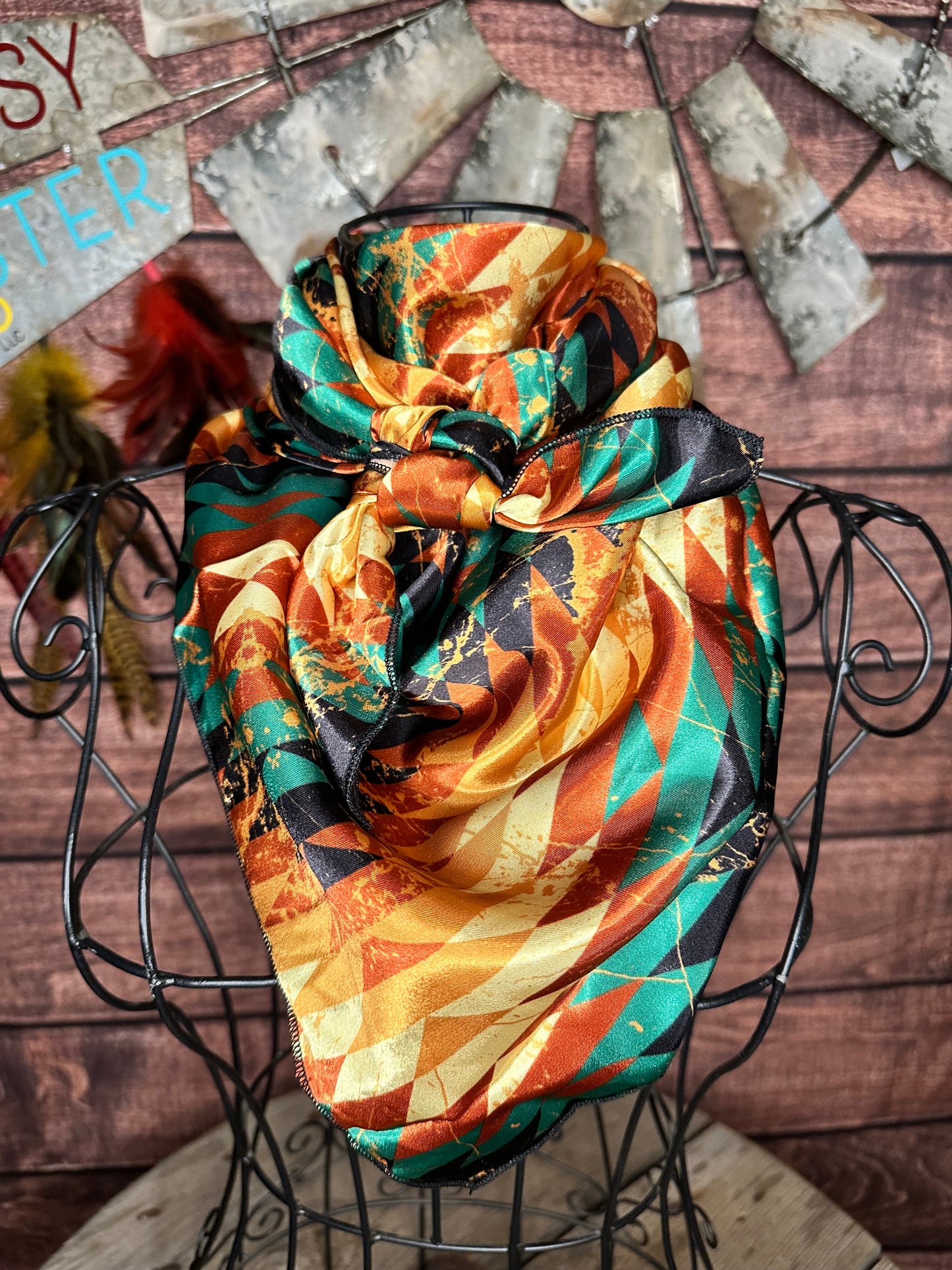 Autumn Aztec Wild Rag: silky wild rag with orange, turquoise and black aztec print tied on a mannequin 