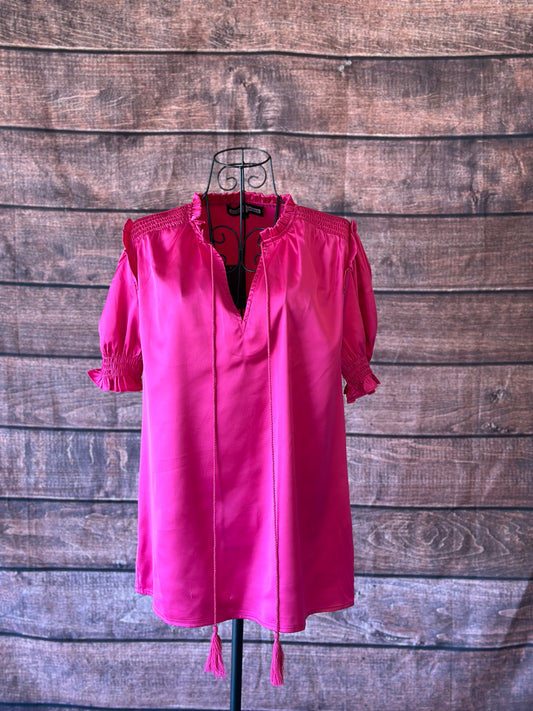 Bright pink short sleeve blouse with a shiny satin like finish on a mannequin