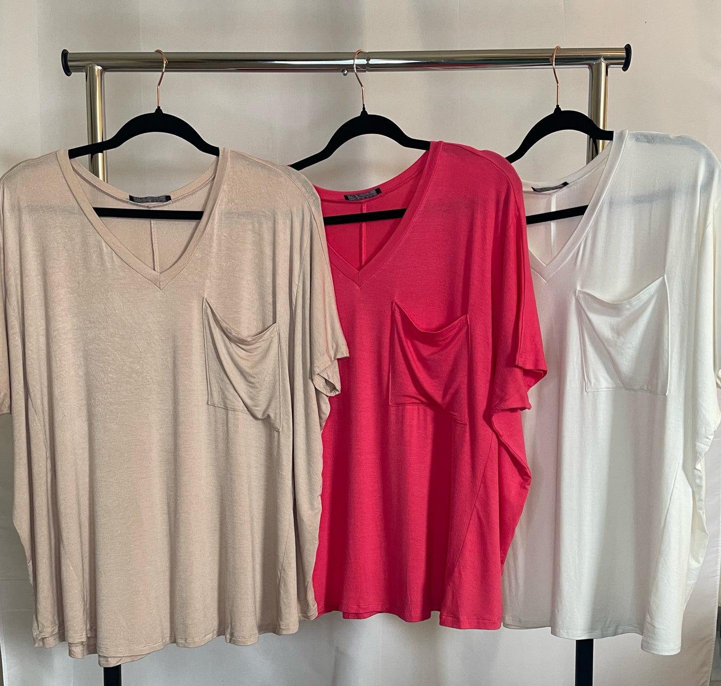 Three oversized v-neck tops with pocket in taupe, coral, and off white