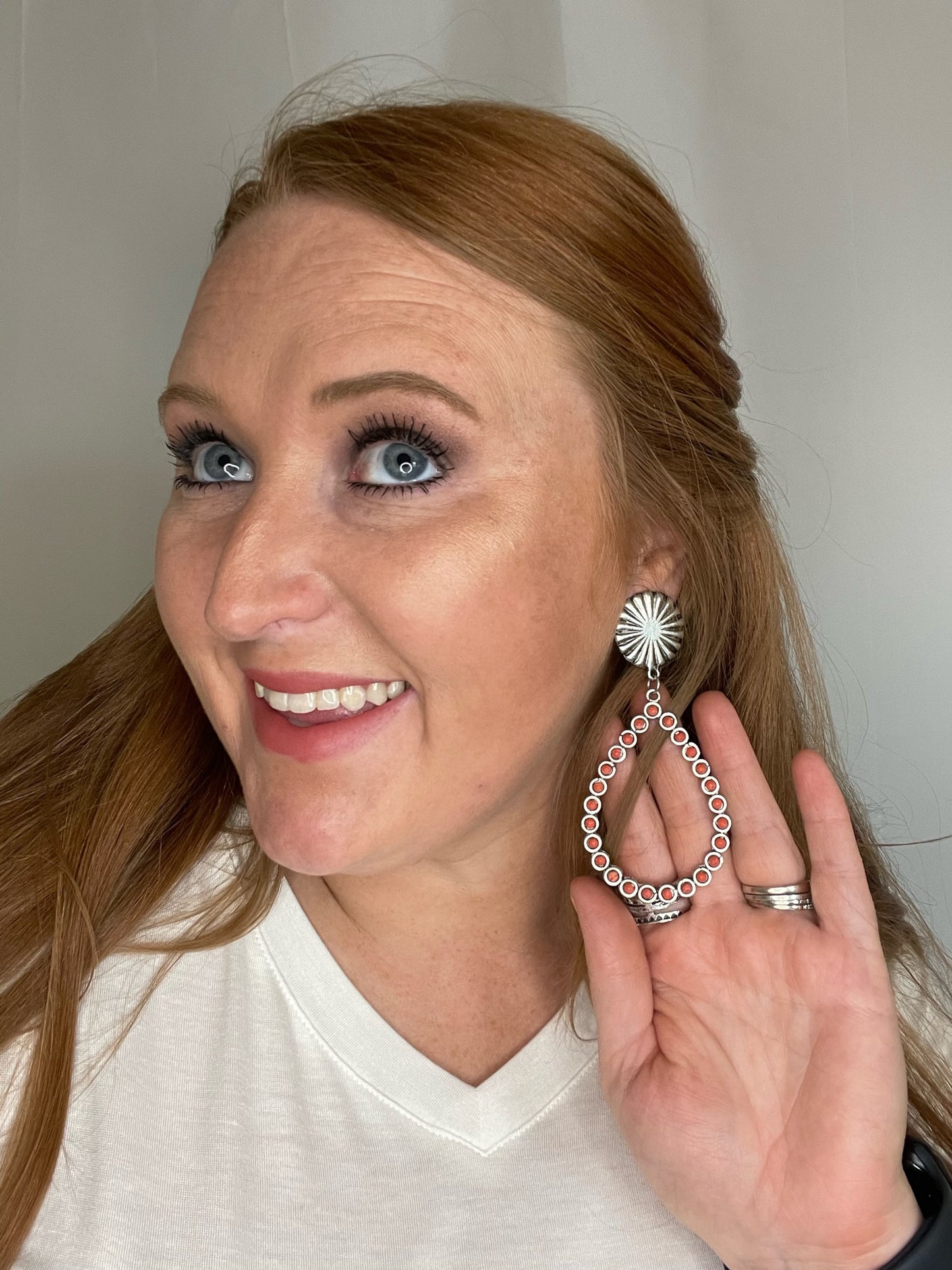 Model wearing Coral studded with silver concho earring 