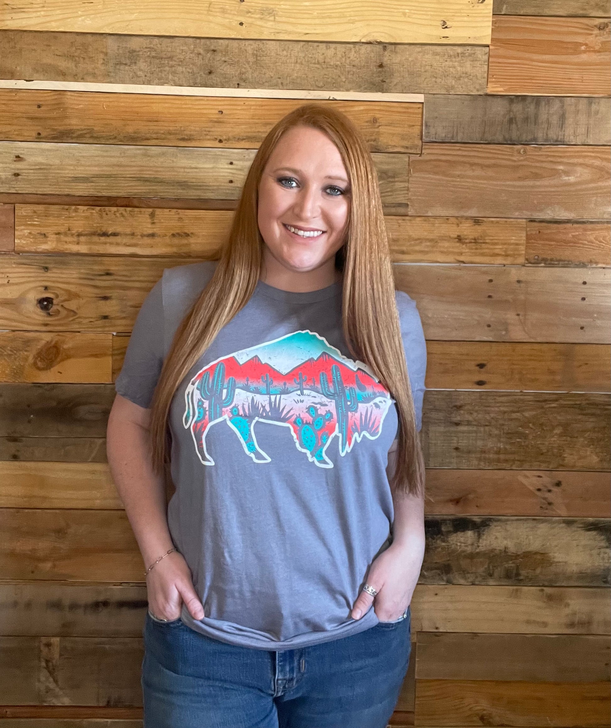Model wearing grey shirt with Buffalo filled with colorful desert scenery in large 