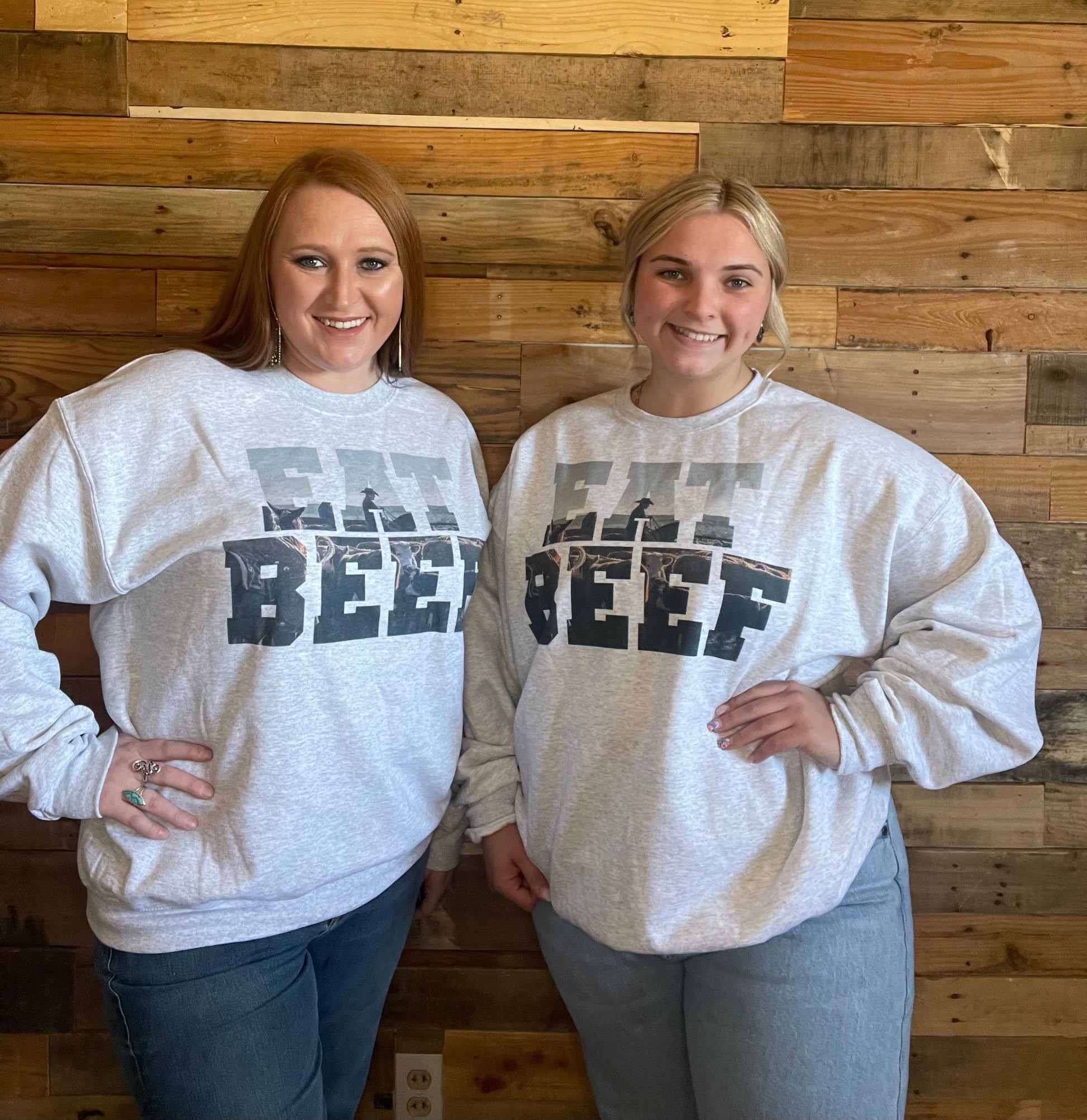 Two models wearing Light grey sweat shirt that says Eat Beef with a cowboy and cow in the letters