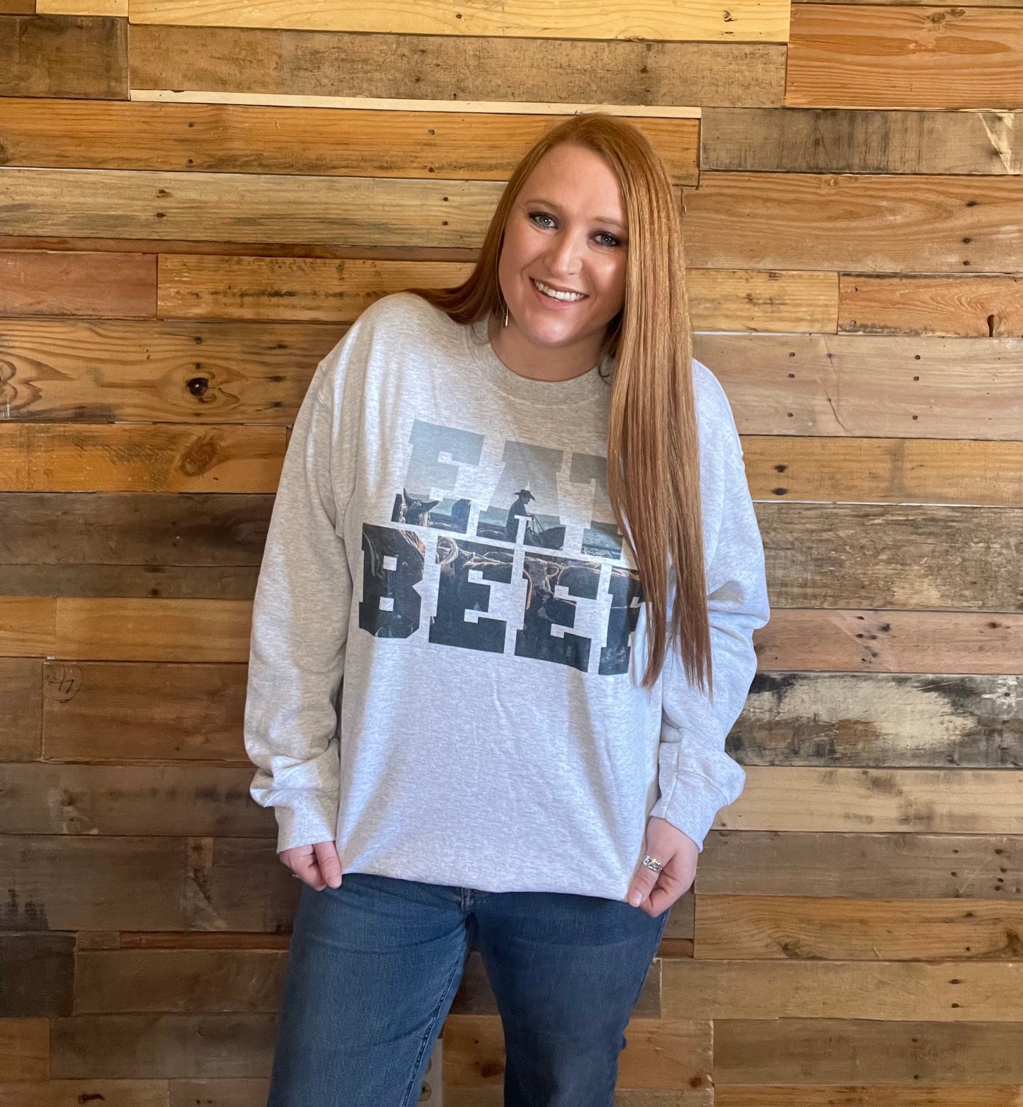 Model wearing Light grey sweat shirt that says Eat Beef with a cowboy and cow in the letters in Large