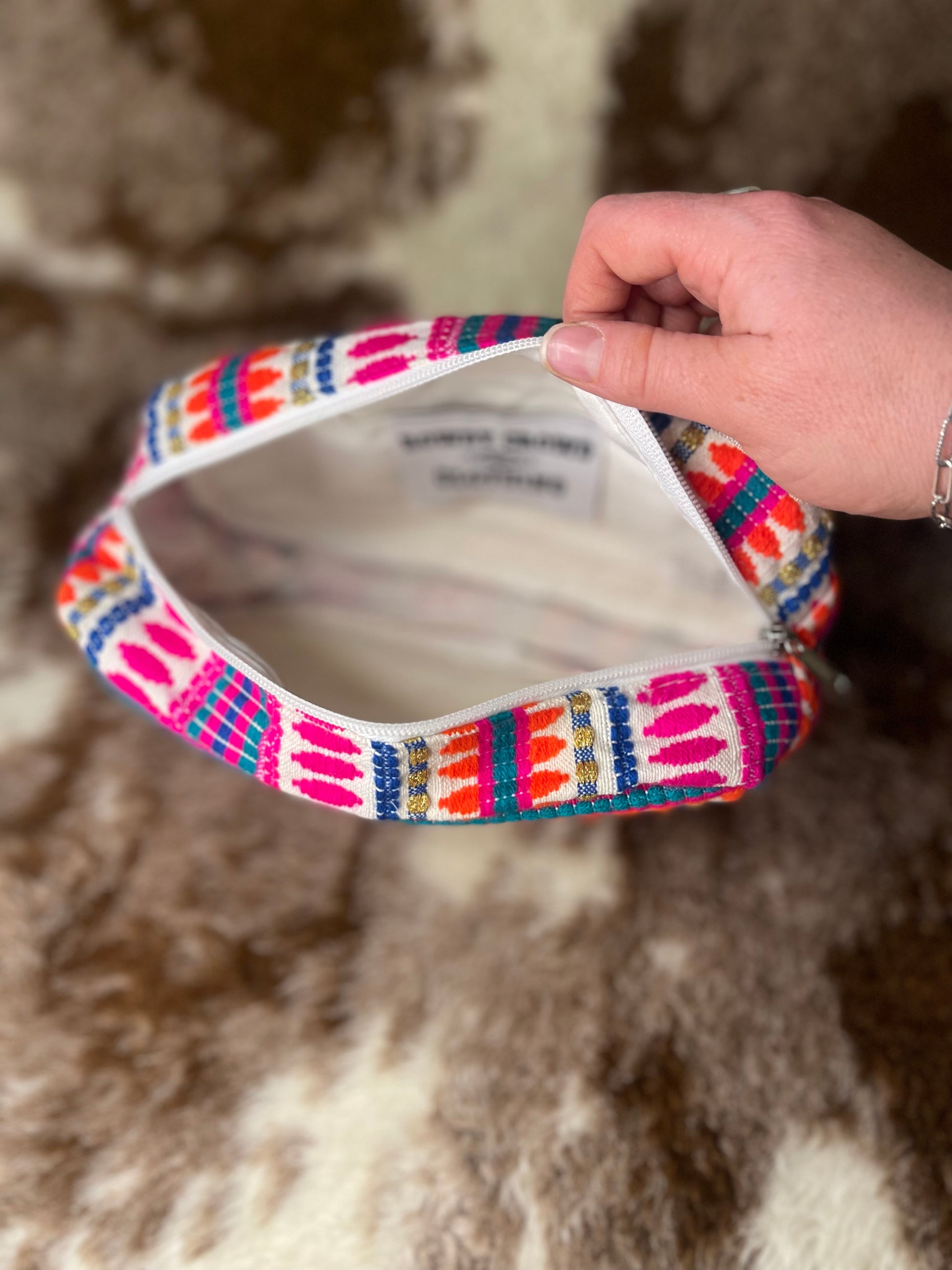 Inside view of colorful, pink, white, orange, blue, and green printed makeup bag 